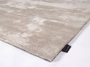 Tapis beige en viscose photographié en angle, mettant en valeur ses contours et sa finition
