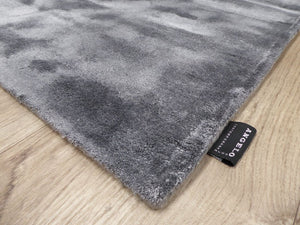 Tapis gris en viscose photographié de biais, mettant en valeur les reflets et la finition des bords