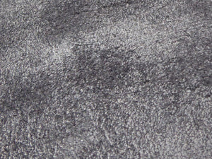 Gros plan sur la surface brillante et douce du tapis en viscose gris, soulignant ses nuances de couleur