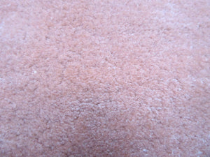 Détail en gros plan du tapis viscose pêche rose, montrant la texture brillante douce