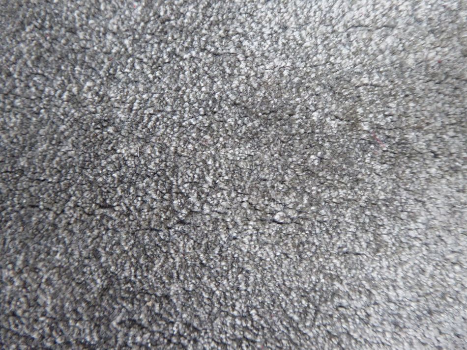 Détail rapproché du tapis en viscose gris, révélant la douceur et l’éclat de sa surface
