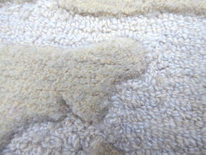 Gros plan sur le tapis ivoire en laine et viscose, montrant le contraste de relief, de matière, de douceur et de brillance