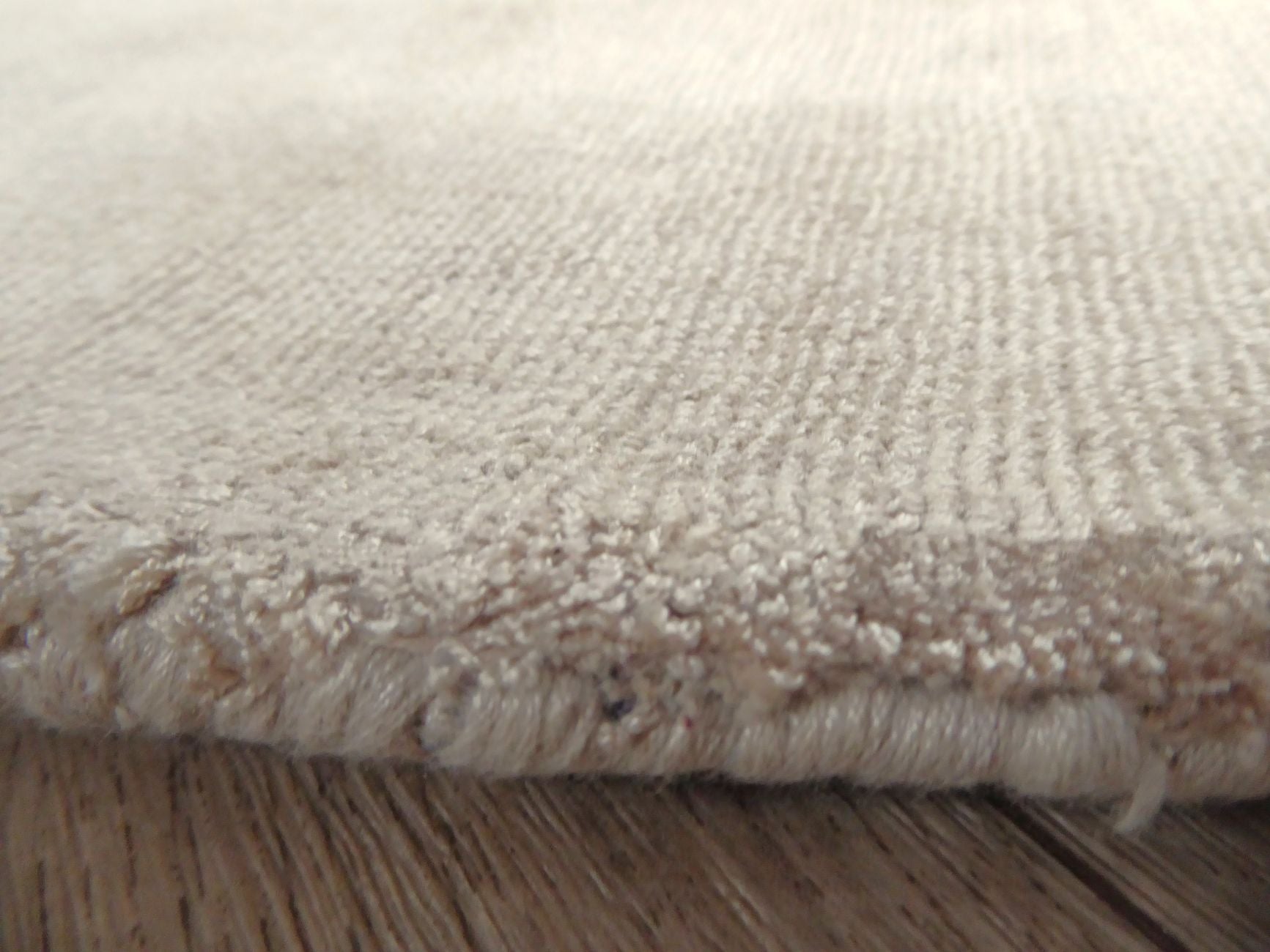 Bord du tapis rond beige en viscose – finitions soignées, reflet soyeux et épaisseur raffinée