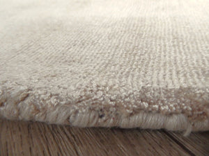 Bord du tapis rond beige en viscose – finitions soignées, reflet soyeux et épaisseur raffinée