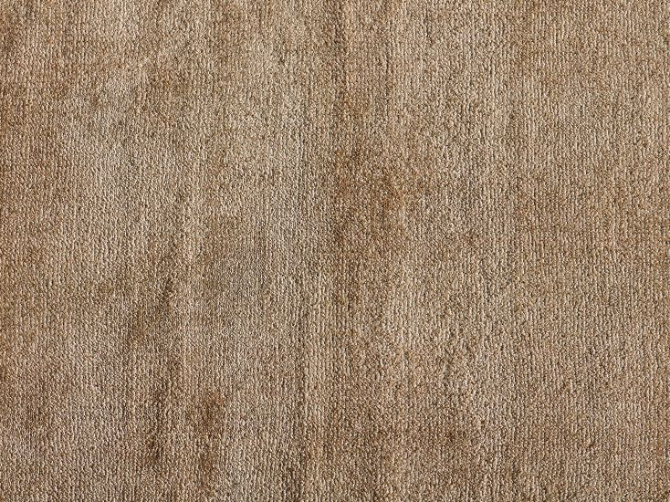 Gros plan sur la texture du tapis luxueux sable — fibres de viscose brillantes et douces à la lumière