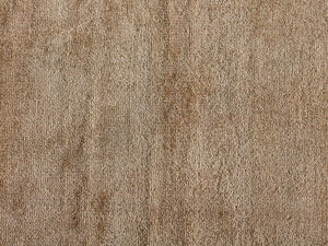 Gros plan sur la texture du tapis luxueux sable — fibres de viscose brillantes et douces à la lumière