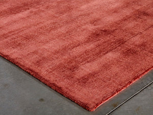 Tapis rouge en viscose vu en angle, mettant en valeur sa brillance et ses finitions raffinées