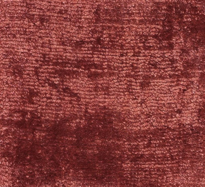 Détail du tapis rouge en viscose, gros plan sur la texture douce et la brillance du fil