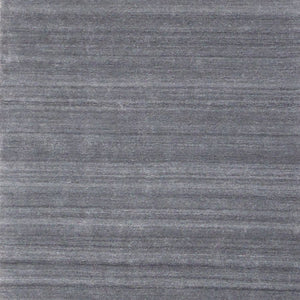 Zoom sur le tapis en laine et viscose — détail de la texture et du motif blanc gris