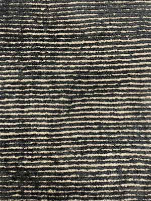 Gros plan sur la texture du tapis or noir – détails du tissage mêlant laine et polyamide, effet brillant et sophistiqué