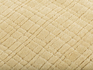 Gros plan du tapis beige jaune pâle montrant la texture tissée à la main en PET recyclé et son motif carreaux subtil