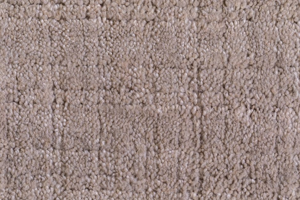 Gros plan sur la texture tissée du tapis rose pâle en PET recyclé, mettant en avant détails du motif subtil à carreaux