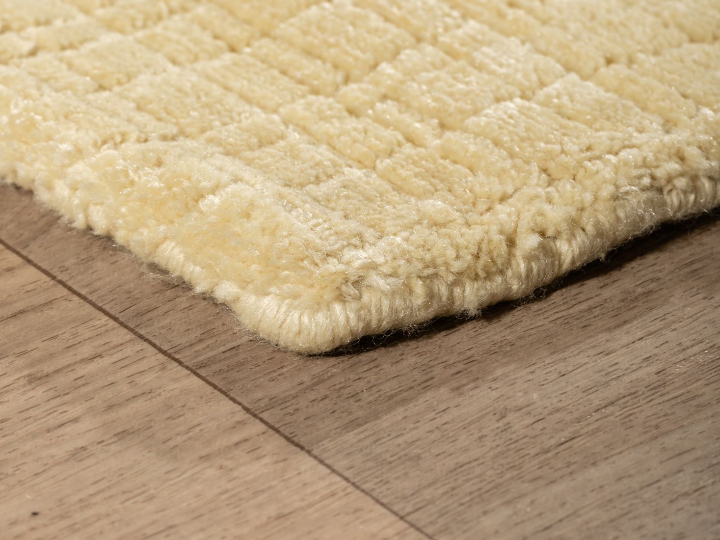 Tapis jaune pâle vu en angle, mettant en valeur les finitions artisanales et la qualité du tissage en PET recyclé