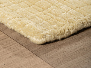 Tapis jaune pâle vu en angle, mettant en valeur les finitions artisanales et la qualité du tissage en PET recyclé