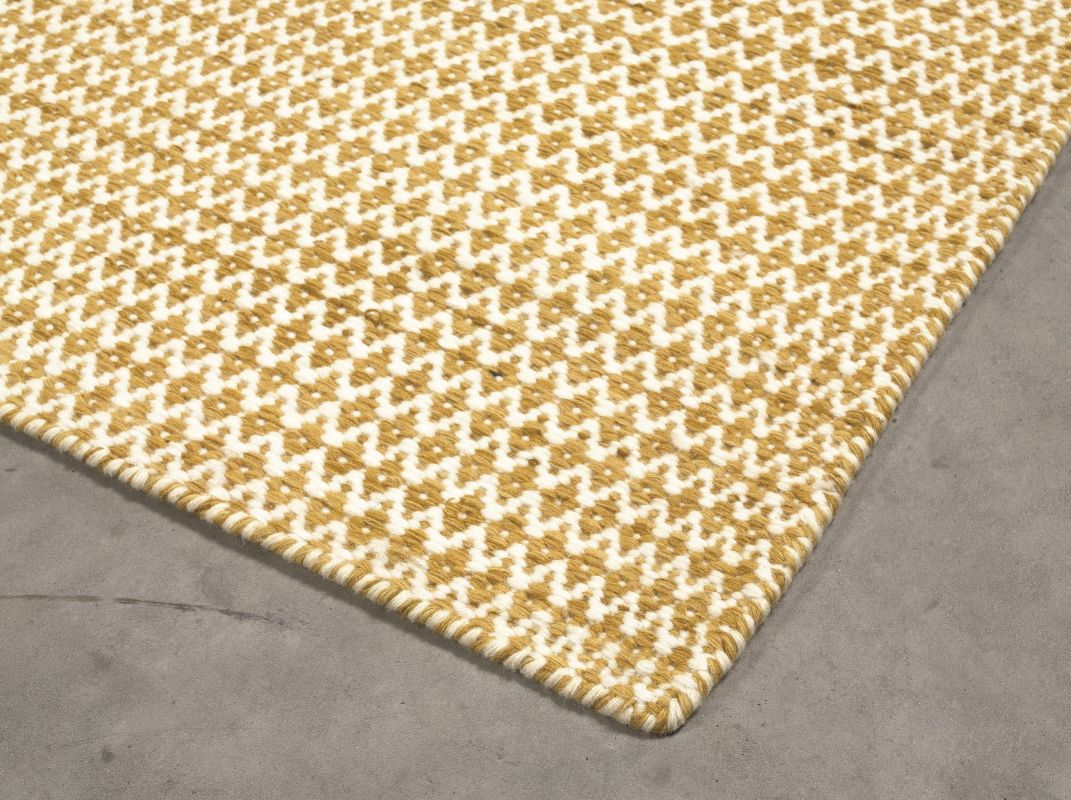 Tapis moderne en laine tissée, jaune et blanc lumineux, à motifs losanges graphiques, présenté en angle