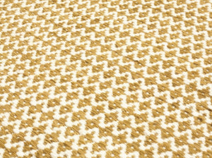 Gros plan sur tapis tissé plat en laine, texture naturelle, motif losange géométrique jaune et blanc