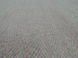 Gros plan sur la texture du tapis tissé main – fibres artisanales et rayures raffinées gris rose