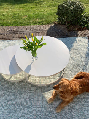 Tapis ethnique blanc et turquoise en PET recyclé posé sur terrasse extérieure, ambiance estivale, motifs géométriques 