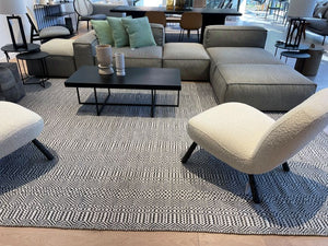 Tapis ethnique en PET recyclé blanc, gris et marine installé dans un salon moderne, ambiance conviviale, matière durable