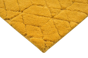 Tapis jaune à formes géométriques en laine, vue en angle mettant en valeur l’épaisseur et les finitions soignées