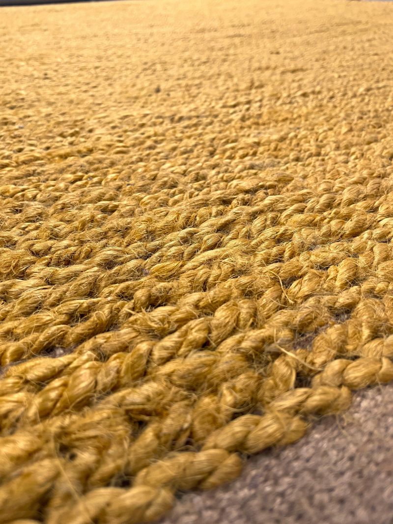 Gros plan sur le tissage du tapis en jute jaune vif. Texture naturelle et élégante, combinant robustesse et douceur