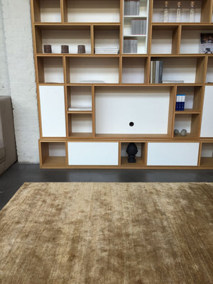 Tapis soyeux en soie de bambou jaune beige doré disposé devant du mobilier élégant, ambiance chaleureuse