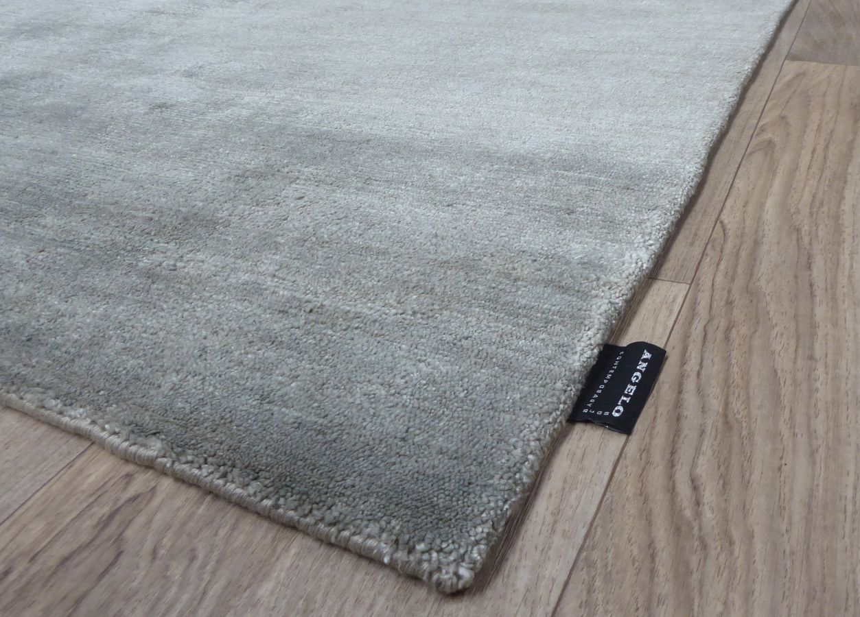 Tapis en soie de bambou gris argenté vu de coin, mettant en valeur la profondeur et la brillance du textile