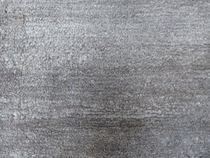 Gros plan sur la texture soyeuse et raffinée du tapis en soie de bambou gris argenté