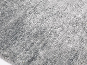 Tapis de luxe en soie de bambou gris raffiné, vue de bord révélant ses finitions et son épaisseur