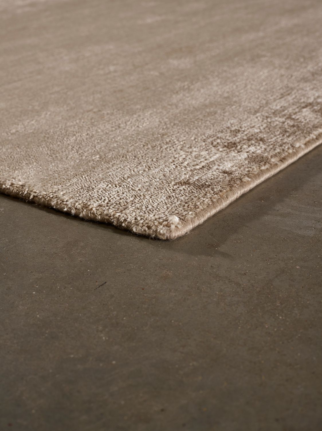 Tapis en soie de bambou marron clair, en vue d’angle, reflétant sa brillance délicate et ses finitions haut de gamme