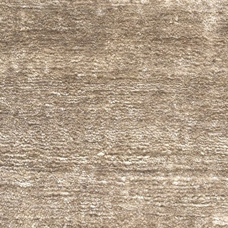 Gros plan sur la texture soyeuse du tapis en soie de bambou marron clair, fibres lumineuses et finition premium