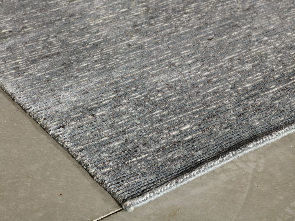 Tapis gris brillant, vu en angle – met en valeur la texture soyeuse et les reflets lumineux du tissage