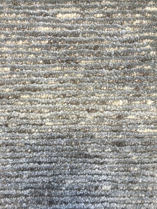 Gros plan sur la texture du tapis gris brillant – détails des nuances de couleurs en laine et soie de bambou