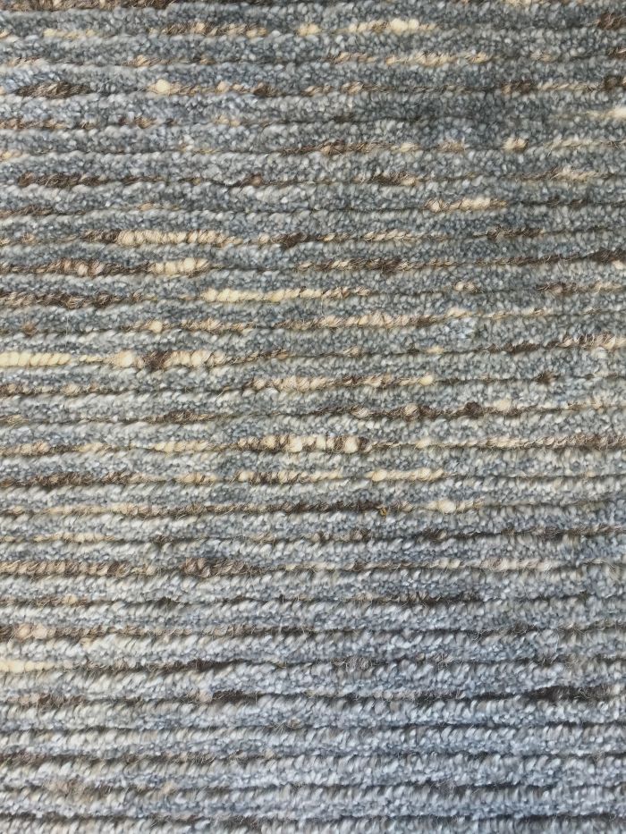 Gros plan sur le tapis bleu – détail du tissage brillant en soie de bambou et laine, texture fine et lumineuse