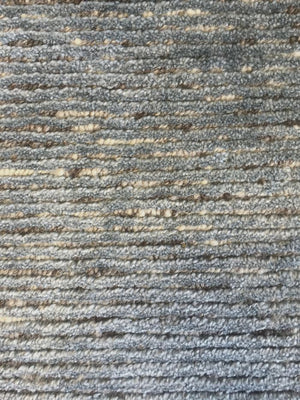 Gros plan sur le tapis bleu – détail du tissage brillant en soie de bambou et laine, texture fine et lumineuse