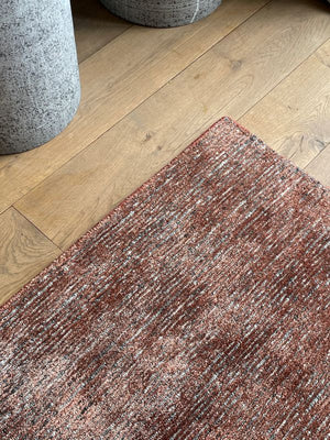 Tapis terracotta gris brillant, vu en angle – met en valeur la texture soyeuse et les nuances subtiles du tissage