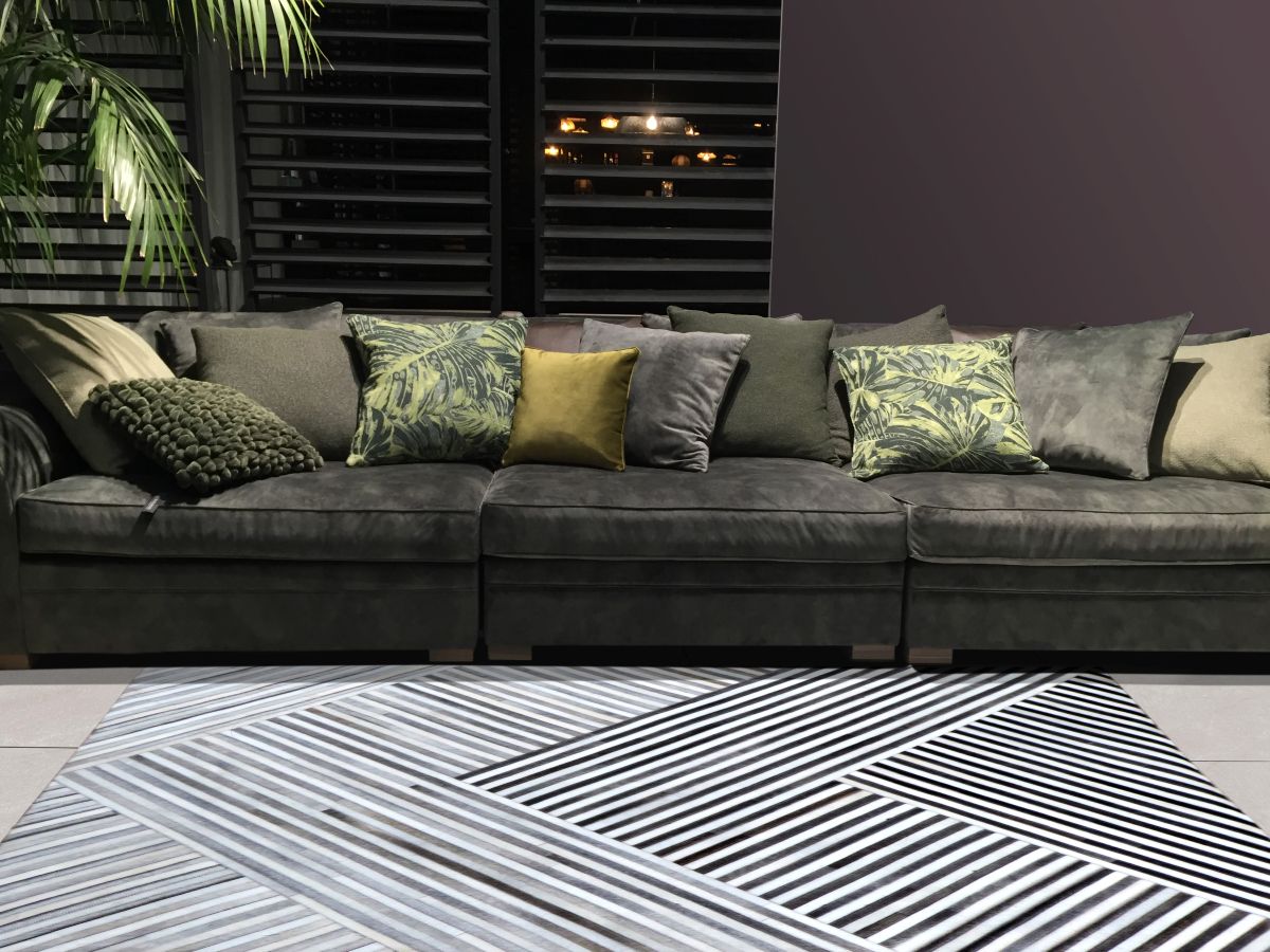 Tapis géométrique en cuir de vachette brun et blanc intégré dans un salon moderne chaleureux