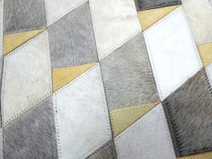 Gros plan sur la texture du cuir de vachette et les motifs géométriques gris ivoire jaune du tapis