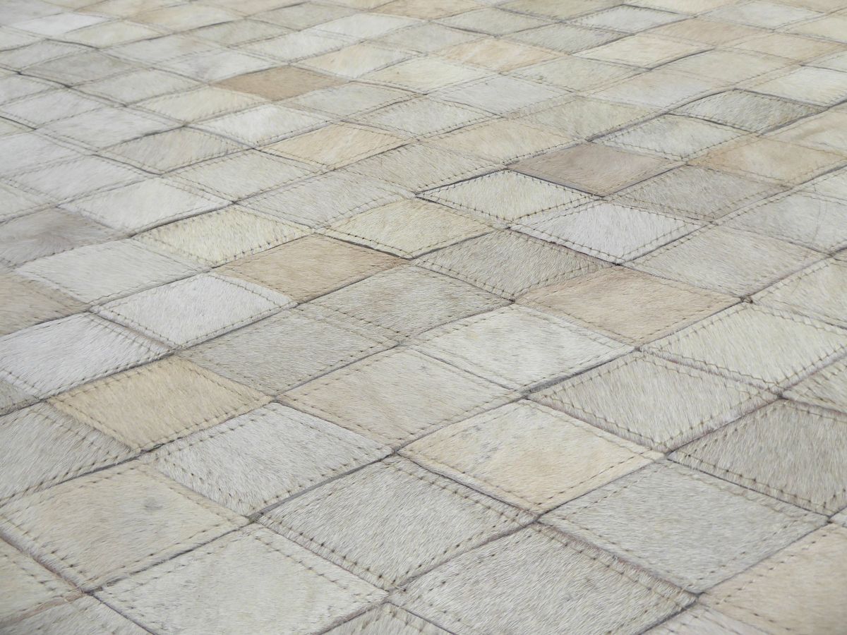 Détail rapproché du cuir de vachette et des motifs géométriques brun gris ivoire, texture visible