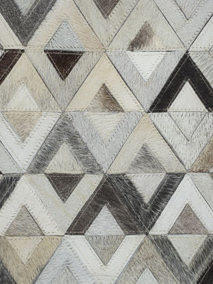 Gros plan sur le cuir de vachette et la texture géométrique gris brun ivoire du tapis