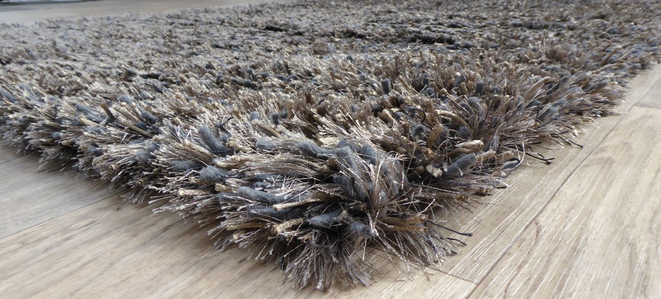 Élégant tapis gris foncé bronze brillant photographié en angle, montrant l’épaisseur et la brillance des fibres