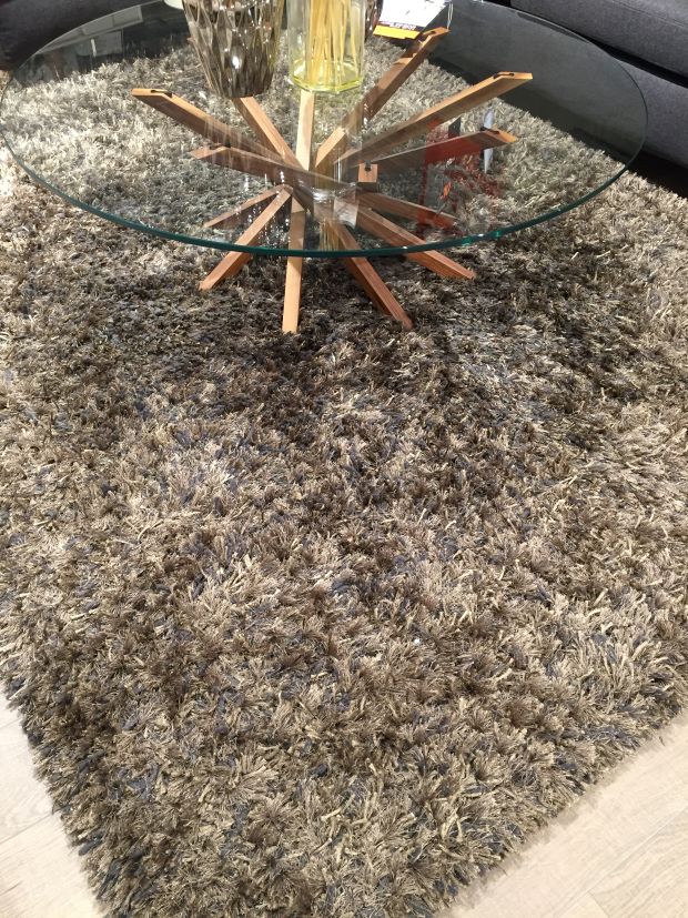 Tapis à poils longs gris bronze intégré dans un salon moderne, créant une ambiance chaleureuse et raffinée