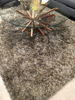 Tapis à poils longs gris bronze intégré dans un salon moderne, créant une ambiance chaleureuse et raffinée