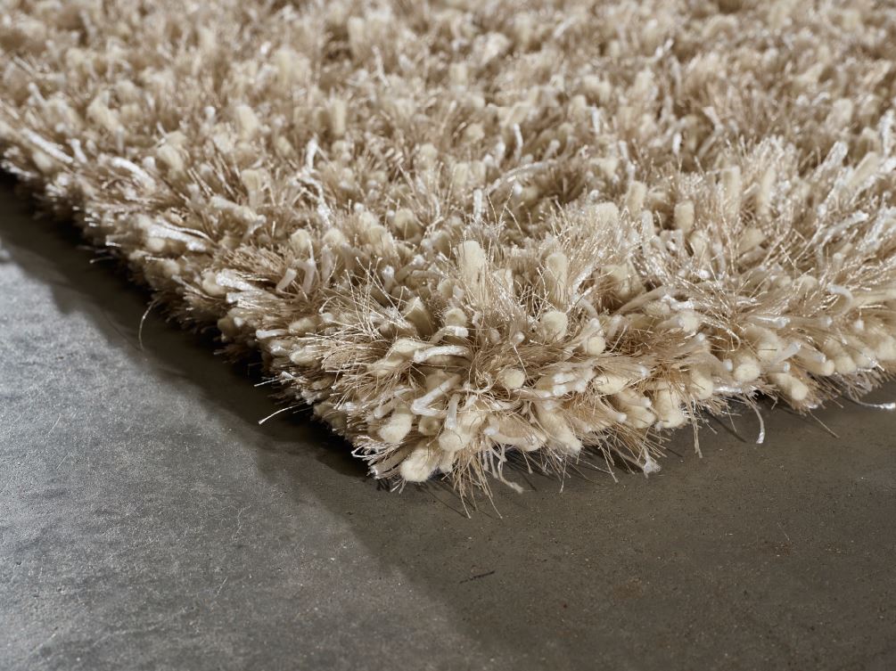 Tapis beige doré à poils longs, aperçu en angle pour montrer son épaisseur et la douceur de ses fibres