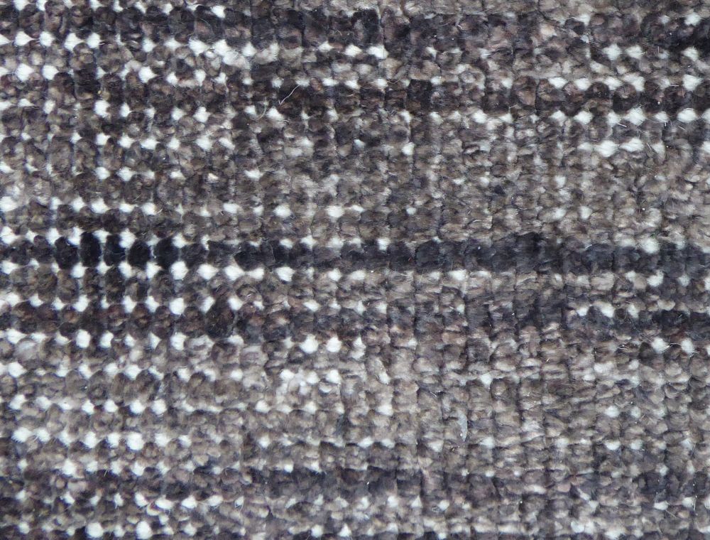 Gros plan sur le tapis vintage gris foncé blanc en PET recyclé montrant la texture responsable tout terrain