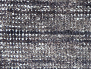 Gros plan sur le tapis vintage gris foncé blanc en PET recyclé montrant la texture responsable tout terrain