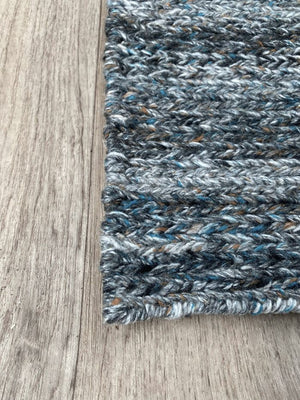 Tapis durable en PET recyclé gris bleu orange présenté en vue de coin, texture résistante adaptée à tout espace