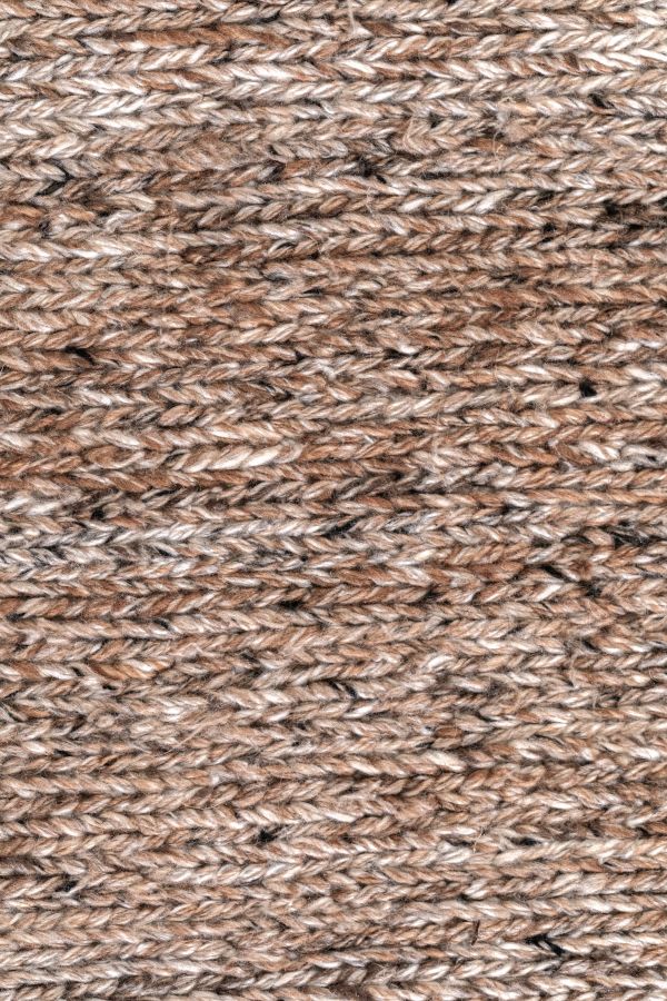 Gros plan sur la texture d’un tapis tout-terrain en PET recyclé brun orange, fibres durables et résistantes