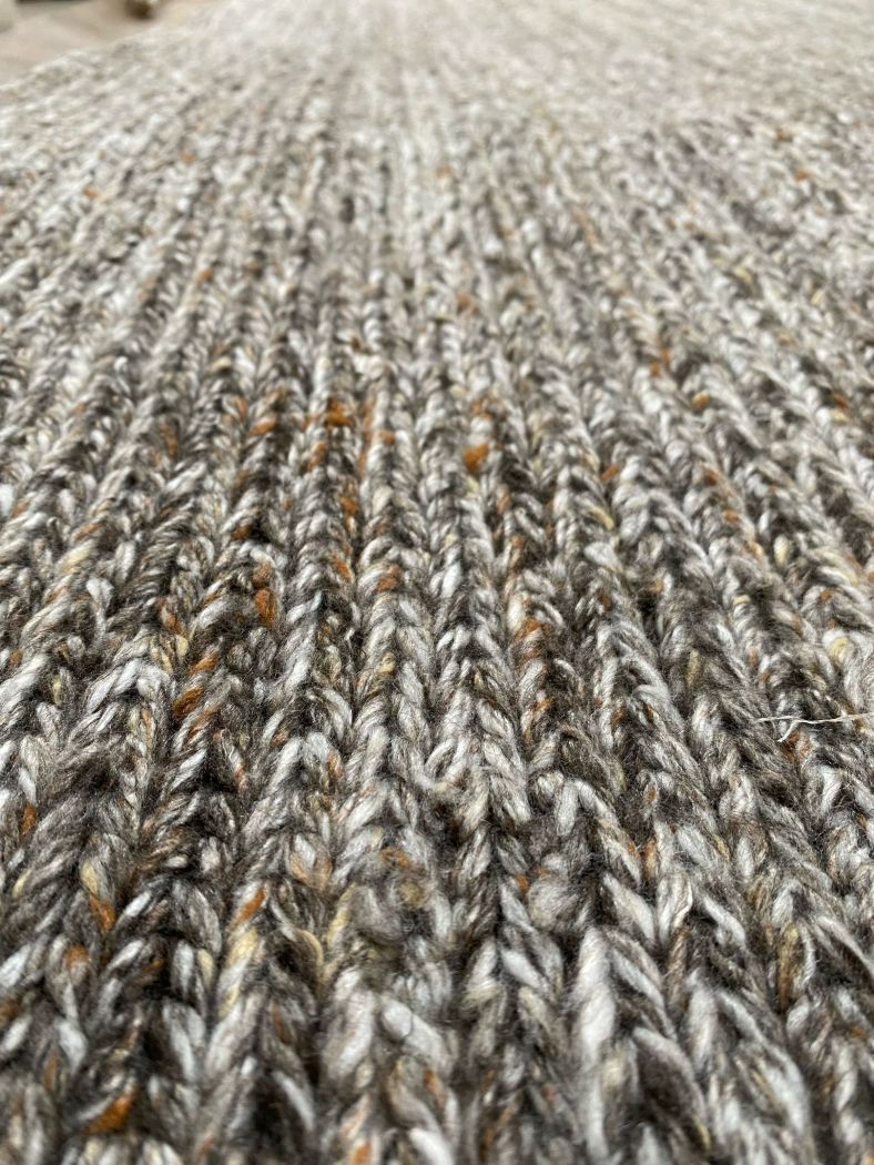 Zoom sur le tapis gris et orange en PET recyclé, détail de la texture tissée et finition durable