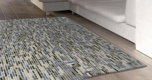 Groot vloerkleed met geometrische patronen, gemaakt van Nieuw-Zeelandse wol en viscose.